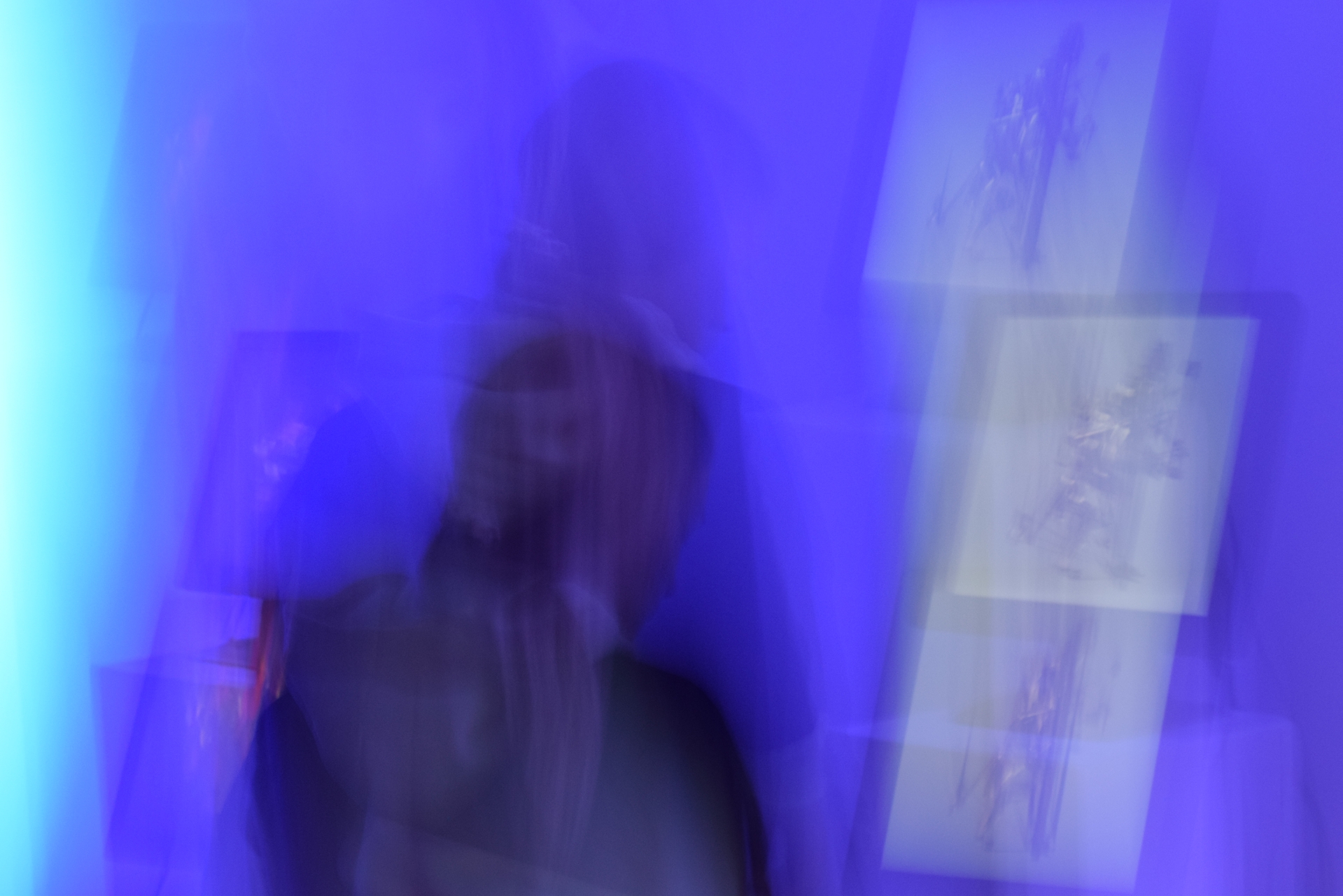 a colorful blurry photograph of a person watching a screen with digital art